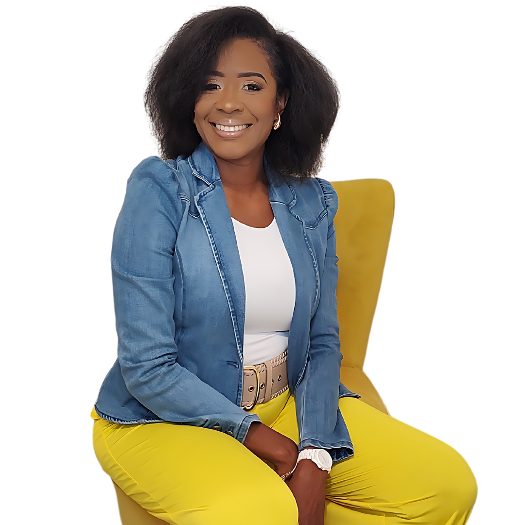A smiling woman in a denim blazer, white top and yellow trousers sits on a mustard-colored chair against a white background.
